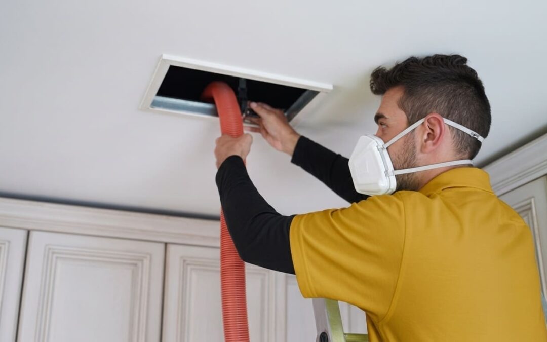 A technician cleans an air duct vent during duct cleaning before a new HVAC installation