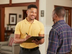 College Hill HVAC services technician consulting with homeowner in living room