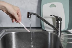 Does Halifax County VA have hard water? A test strip held under a running faucet.