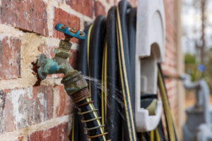 Leaky outdoor spigot shows how hot summer weather affects plumbing