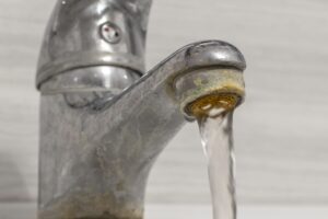 Why is my water pressure suddenly low? Hard water mineral buildup on a faucet.
