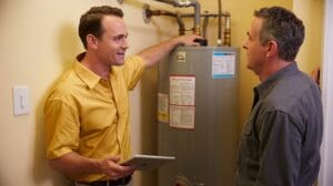 Technician explaining water heater making noise to homeowner